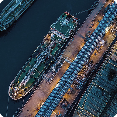 Aerial view of large ships docked at a port at night.